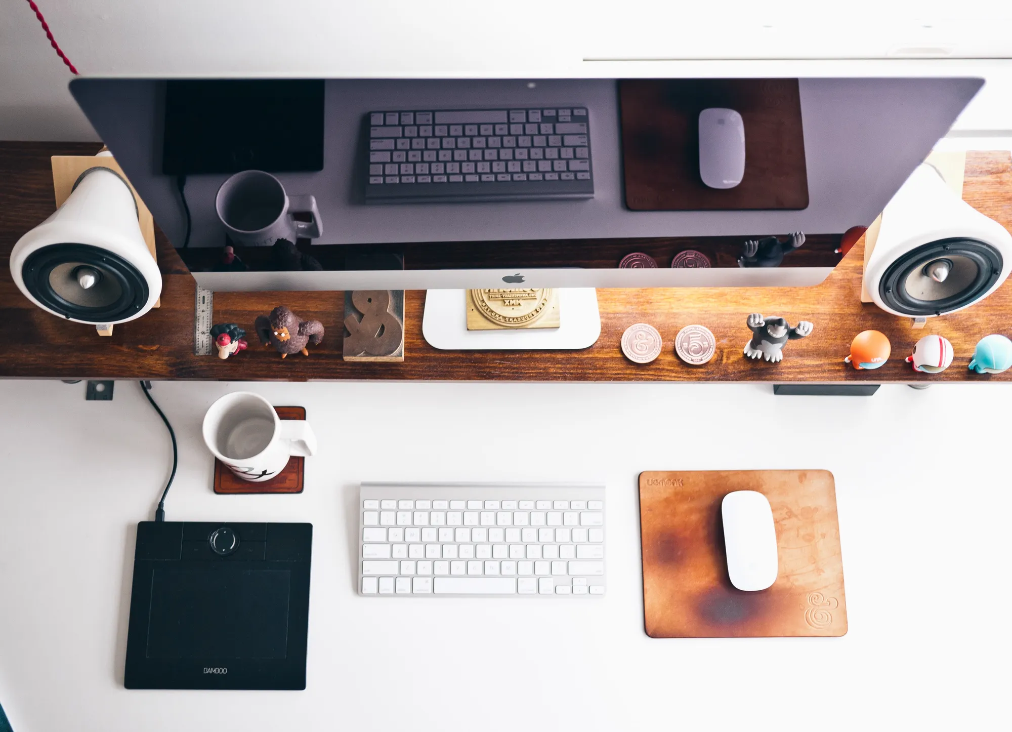 An overhead view of a design desk with a monitor, keyboard, mouse and drawing tablet.