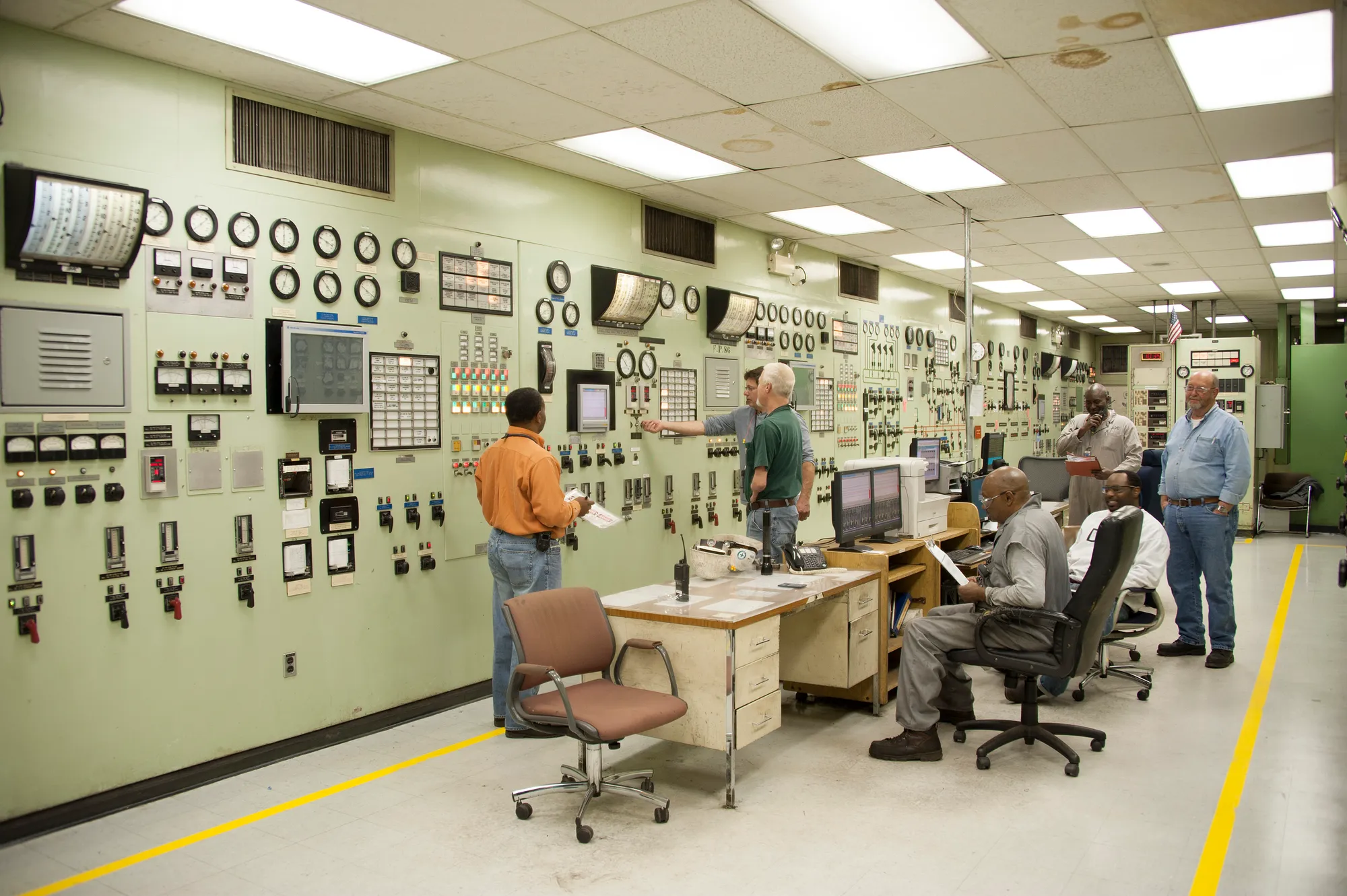 Operators at the control panels of a plant control room.