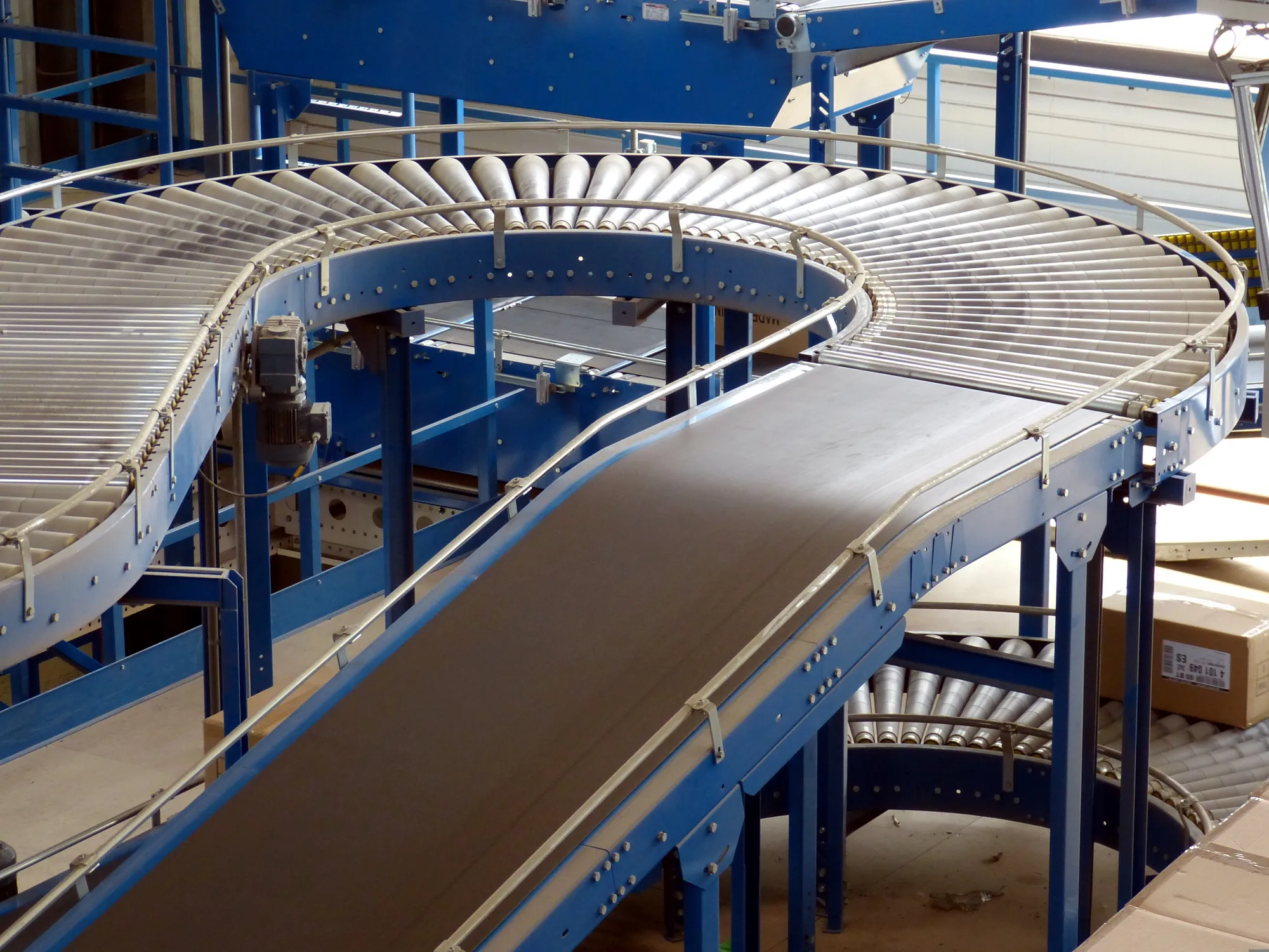 A warehouse conveyor system moving stock between stations.
